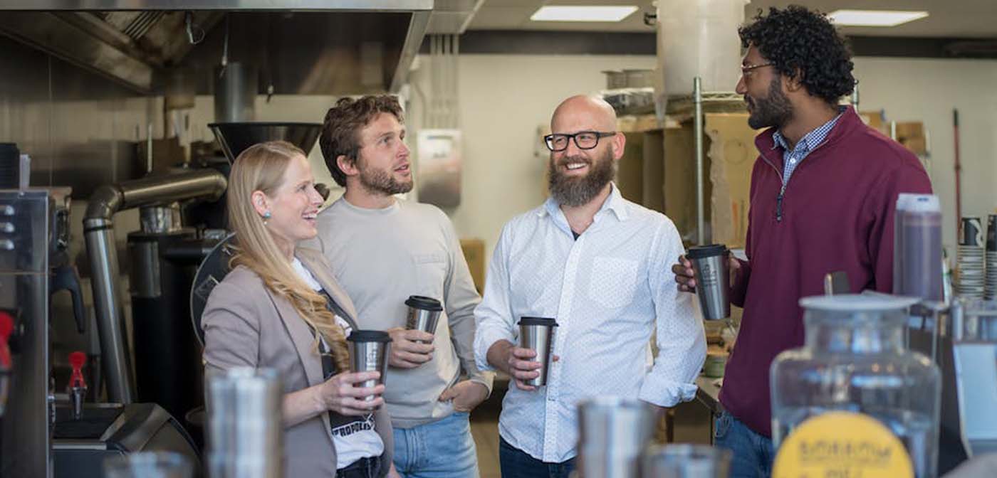 Forever Ware team holding mugs in the kitchen at Roots Roasting in St. Paul, Minnesota.
